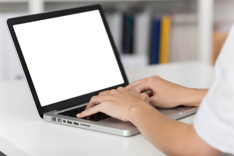 View of hands typing on a laptop