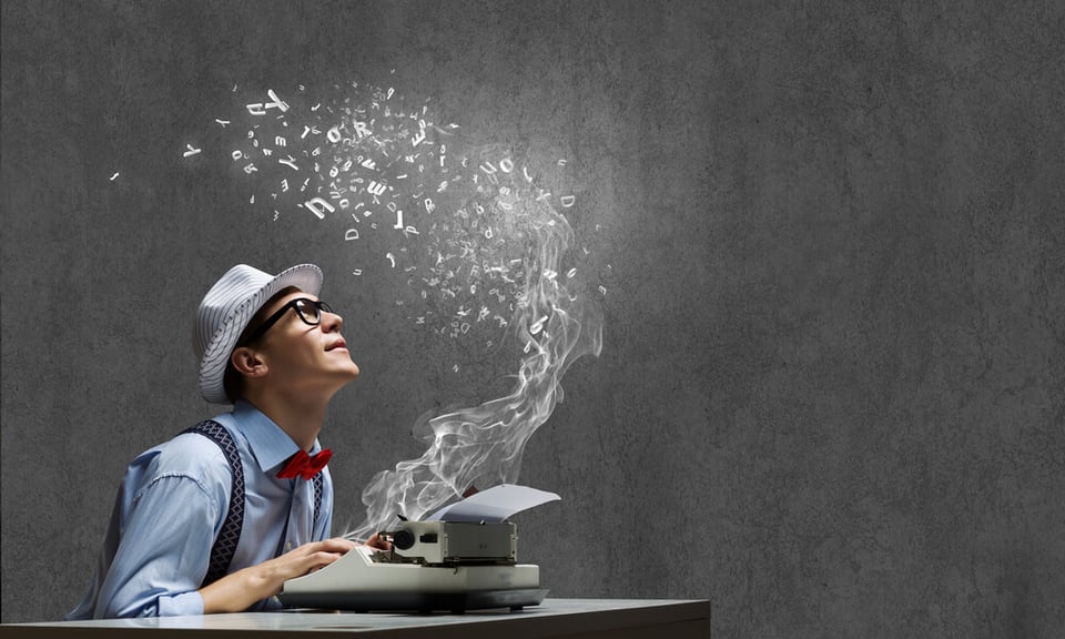 Man with hat and glasses at typewriter with smoky letters seeming to float into the air